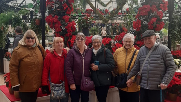 A group of people smiling for the camera in a garden centre
