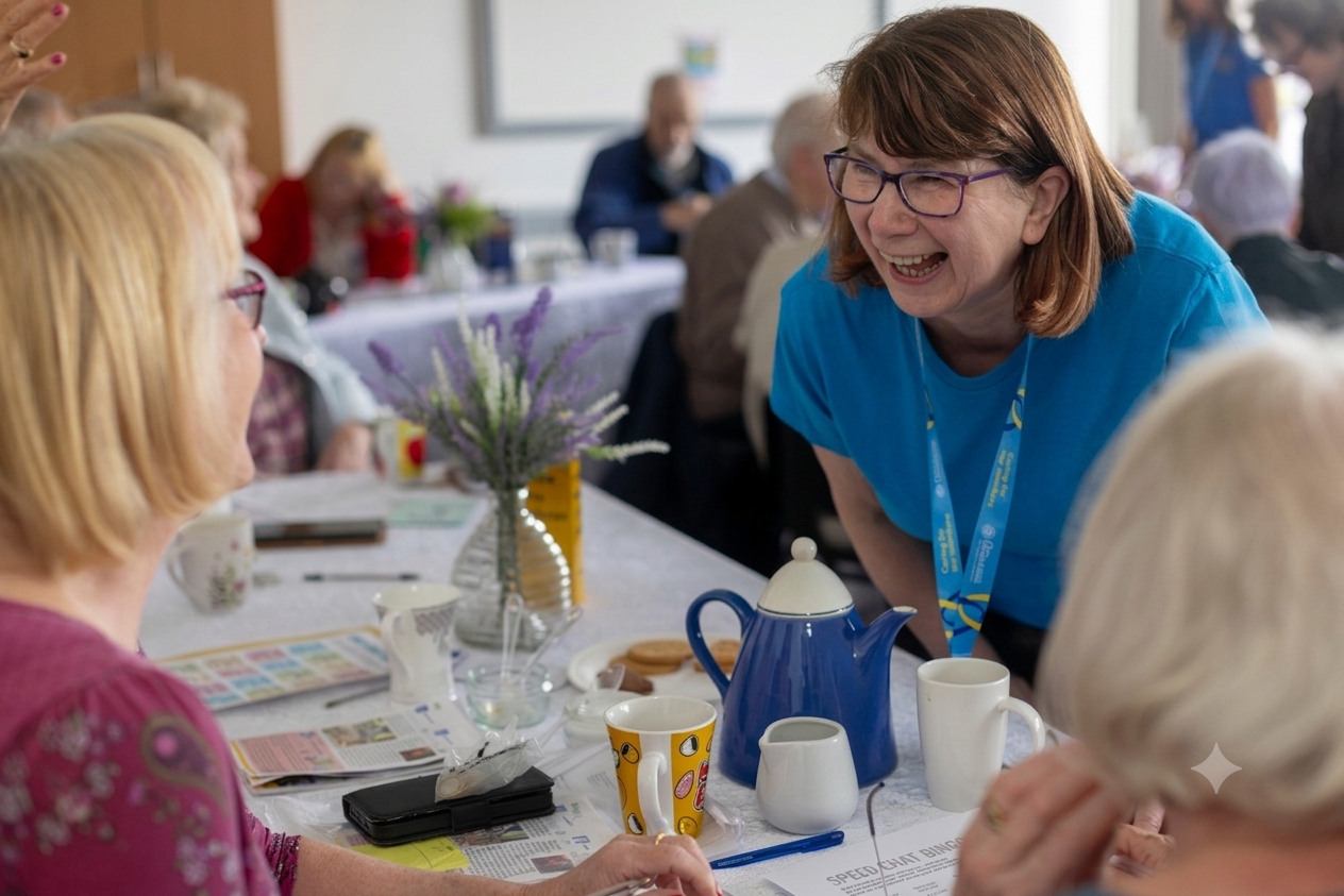 An event host is talking to two members at a table at one of their events