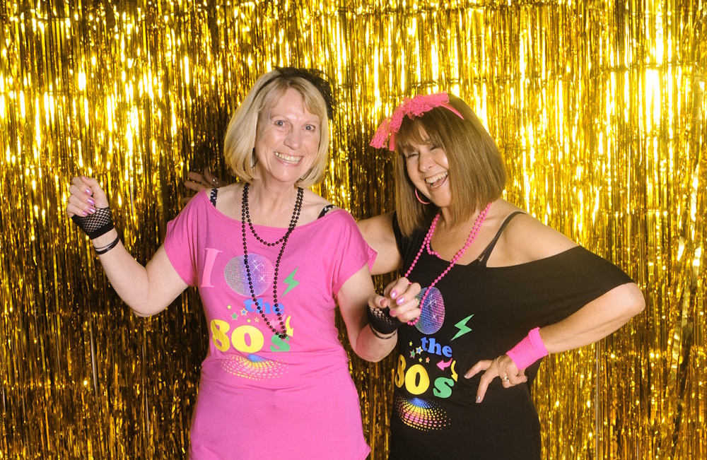 Debbie with friend Karen having fun dressed in 90s clothes at a party
