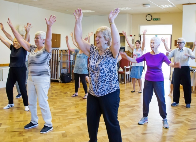 A group of older ladies taking part in an exercise class.