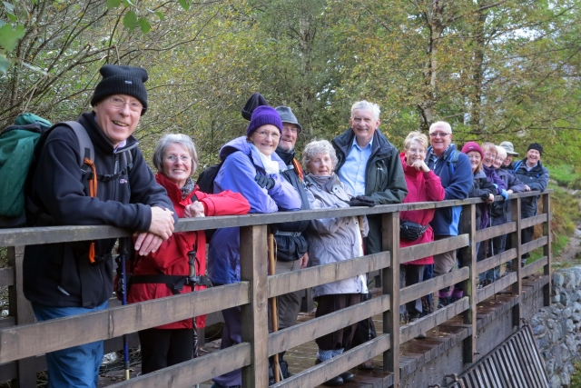 Members on a group walk lined up on a bridge in their walking gear
