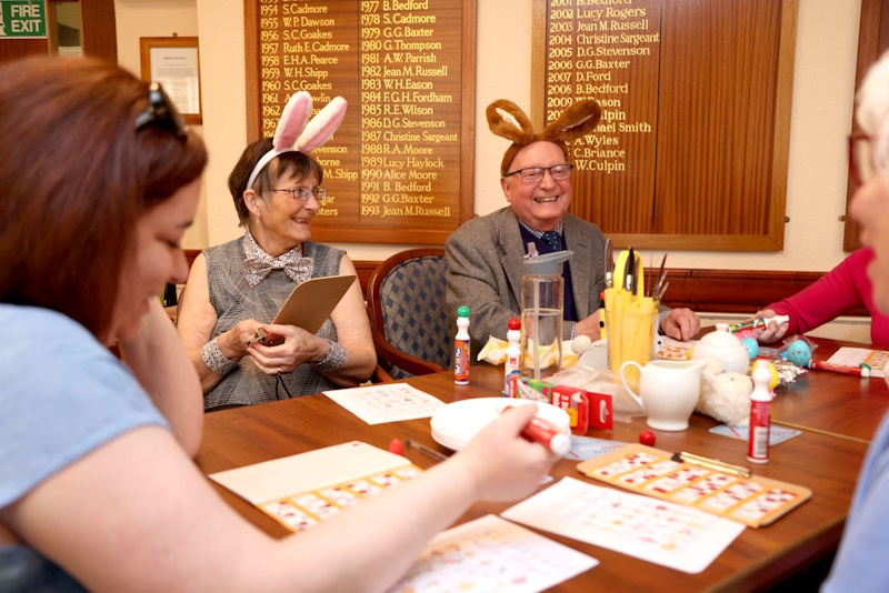 Two people smiling wearing bunny ears