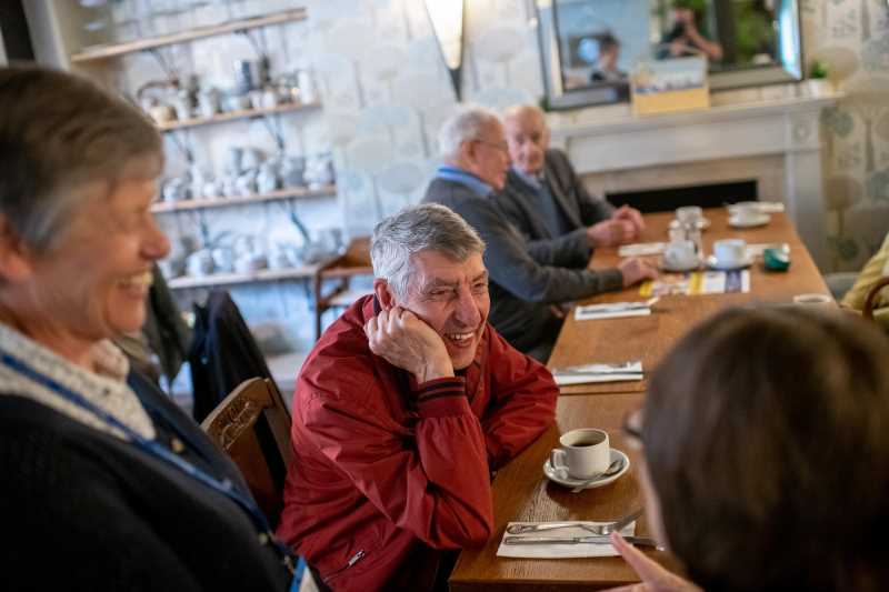 Members chatting round a table enjoying a cup of tea