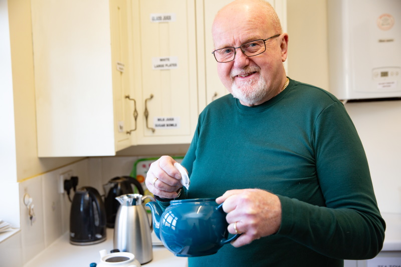 Man making tea in a hall kitchen