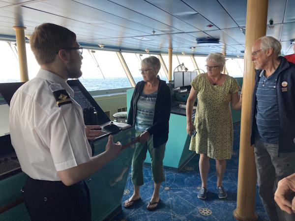A ship employee shows people around the Bridge