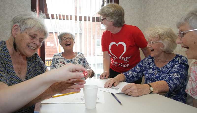 Member sat round a table having fun playing a game of Beetle Drive