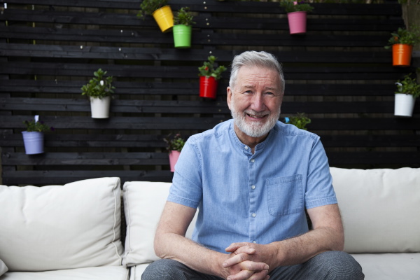 Paul sitting out in his garden and smiling at the camera