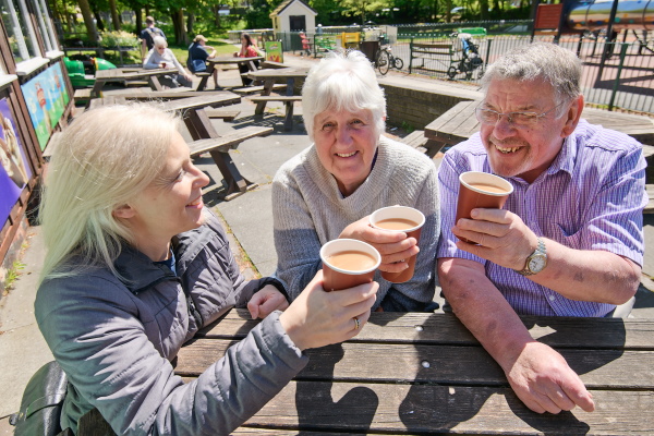 Three Oddfellows members raising a cup of coffee to friendship