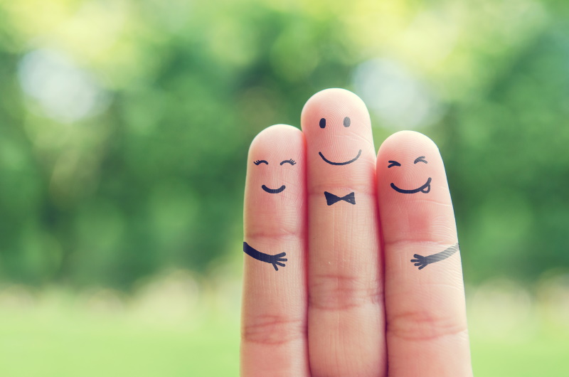 Three fingers being held up with cute hand drawn faces on them