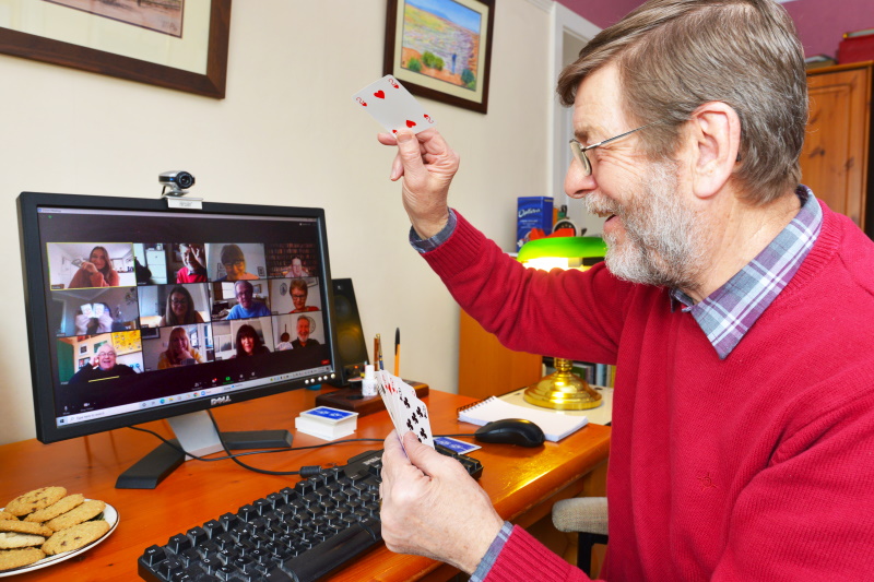 Man sat at his desk in front of his computer taking part in an online social event
