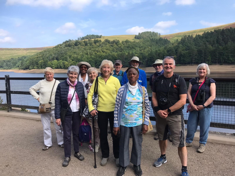 11 Oddfellows members stood next to Derwent Reservoir on a trip.