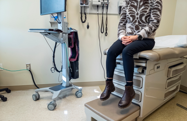 Woman sat waiting for a medical examination surrounded by equipment