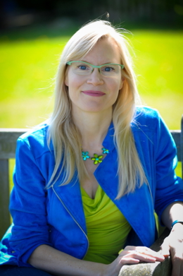 Dr Jennifer Wild looking at the camera, sat on a bench