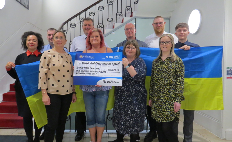 9 Oddfellows staff holding up a big cheque and a Ukrainian flag