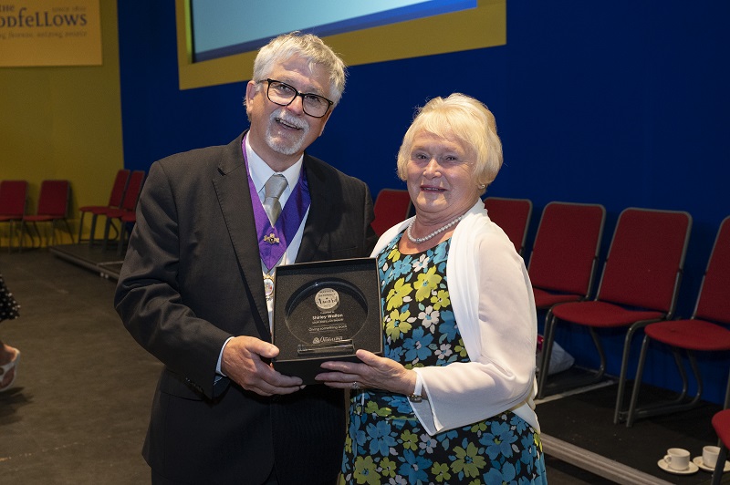 Shirley is presented with her award by Past Grand Master David Randall