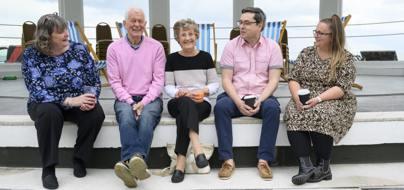 Five Oddfellows members sat in a row outside smiling