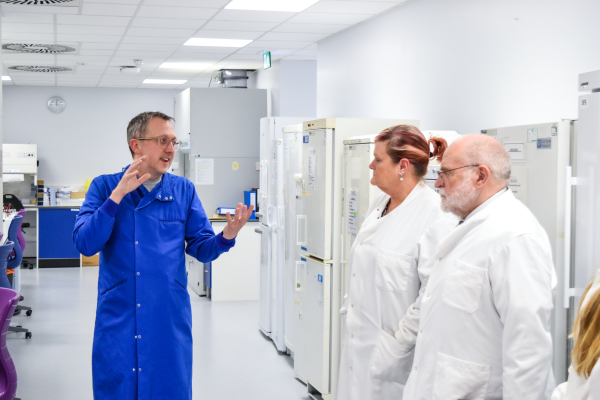 Professor Edd James talks with CEO Jane Nelson and Grand Master David Ogden as he shows them around a white lab