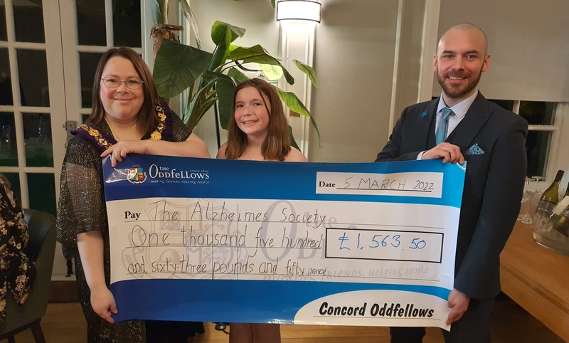 Two representatives from Concord Branch present a cheque to a representative from the Charity.