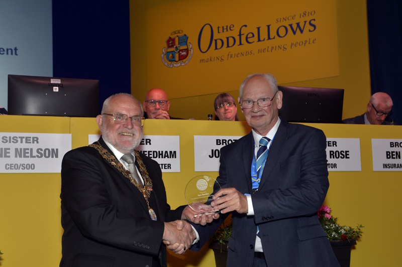 David Smith collecting Sue's trophy on stage from the Society's Chairman, David Ogden