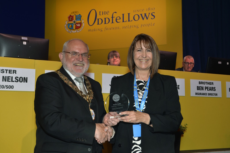 Karen being presented with her trophy on stage by Chairman of the Society, David Ogden