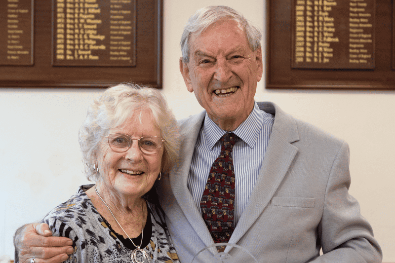 A man with his arm around a woman, both smiling