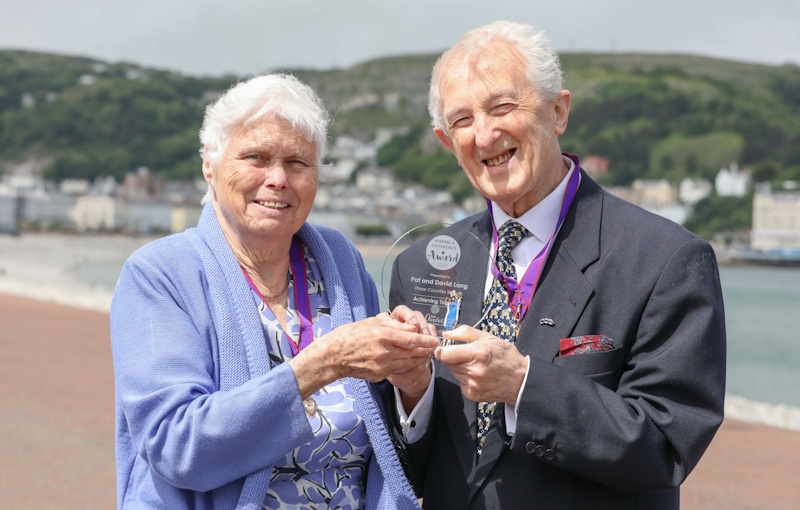 Pat and David smiling and holding their award