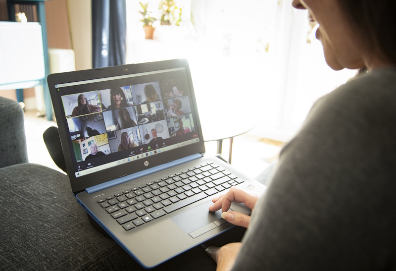 A woman sat with a laptop in an online event