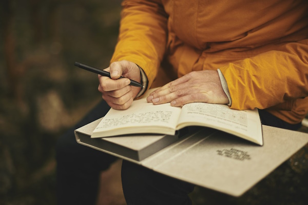 An open note pad with someone writing in it
