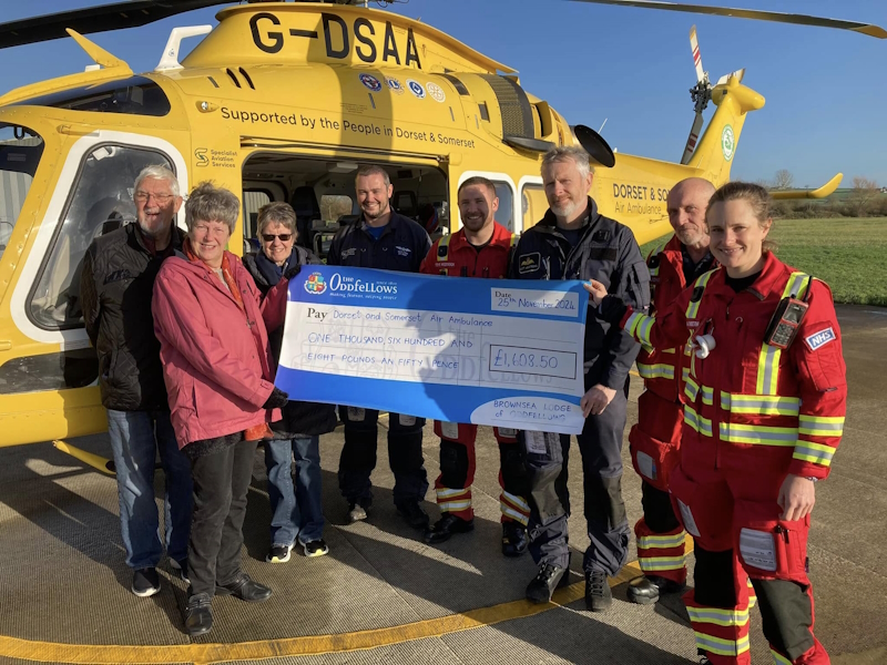 Handing over a big cheque in front of the helicopter
