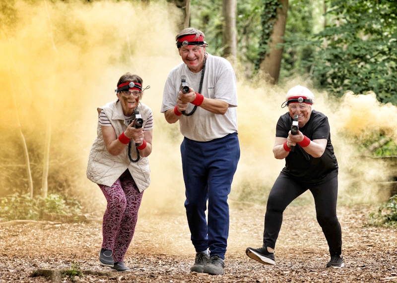 Three older members enjoying a game of laser combat together