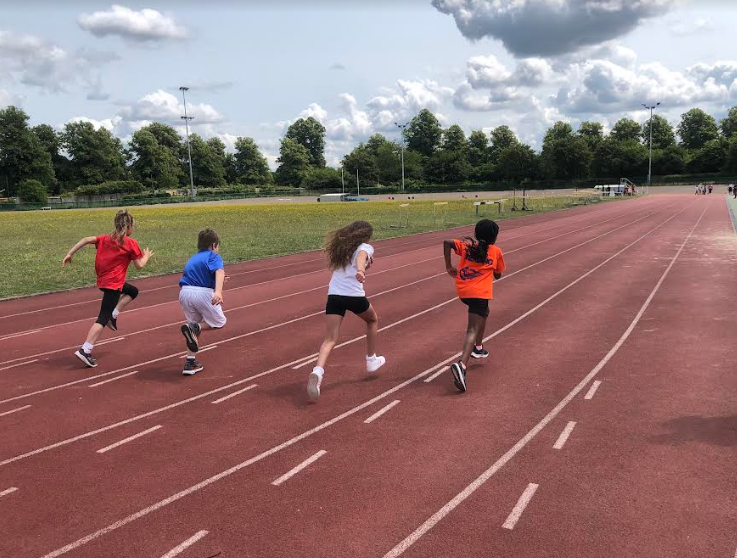 Four children racing on a running track