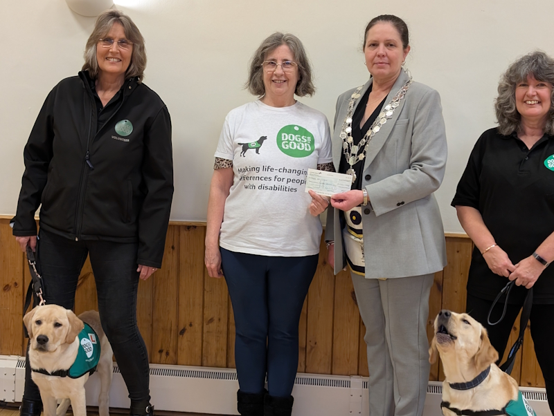 Handing over the cheque. Two service dogs in attendance