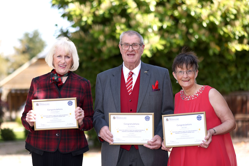 Three people stood holding certificates