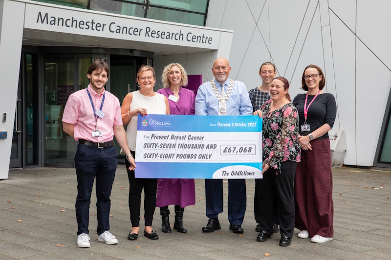 A group holding a big cheque