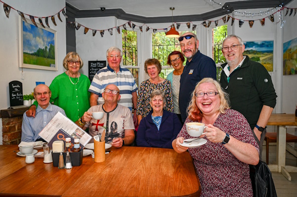A group of people smiling at the camera in a cafe