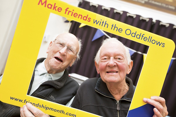 Two men in an Oddfellows frame smiling at the camera