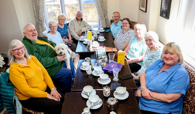 A group of people at around a table smiling