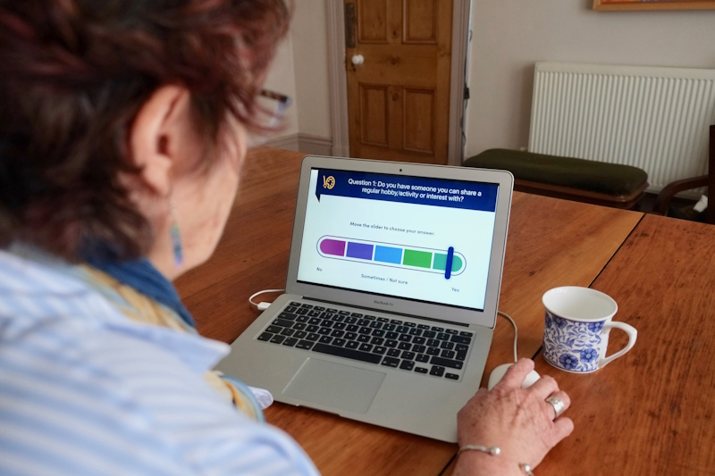 Woman sat in front of a laptop taking a Friendship MOT test online