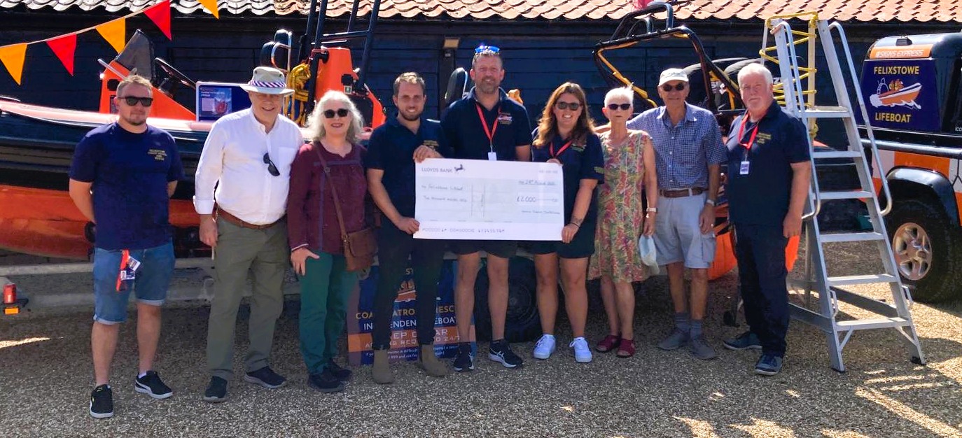 A line up of 9 representatives at the Felixstowe Lifeboat Station nading over the big cheque