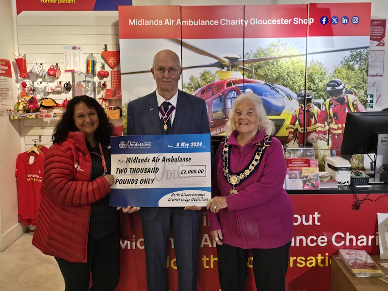 Three people holding a cheque