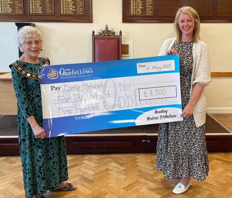 Two people holding an oversized charity cheque.