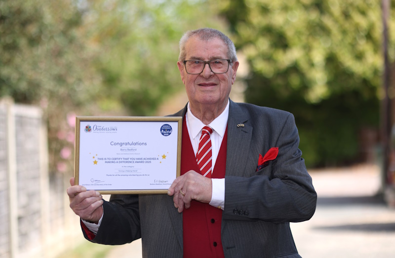 Barry Bedford holds his Making a Difference Award certificate