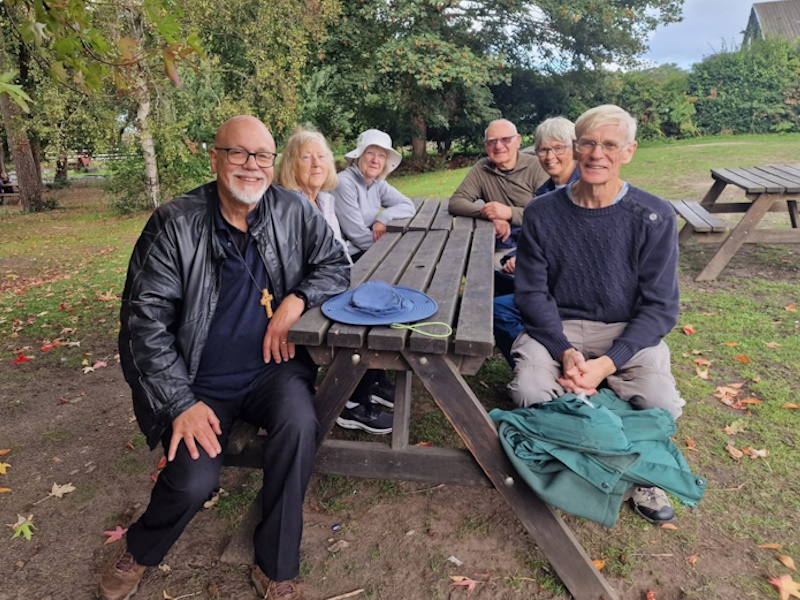 Six members on a bench outside after having been on a group walk. All relaxed and smiling