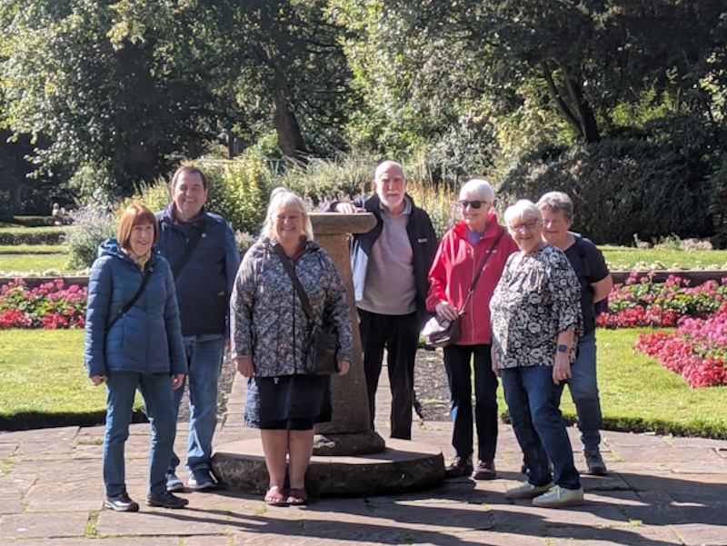 A group of people smiling for the camera in a park