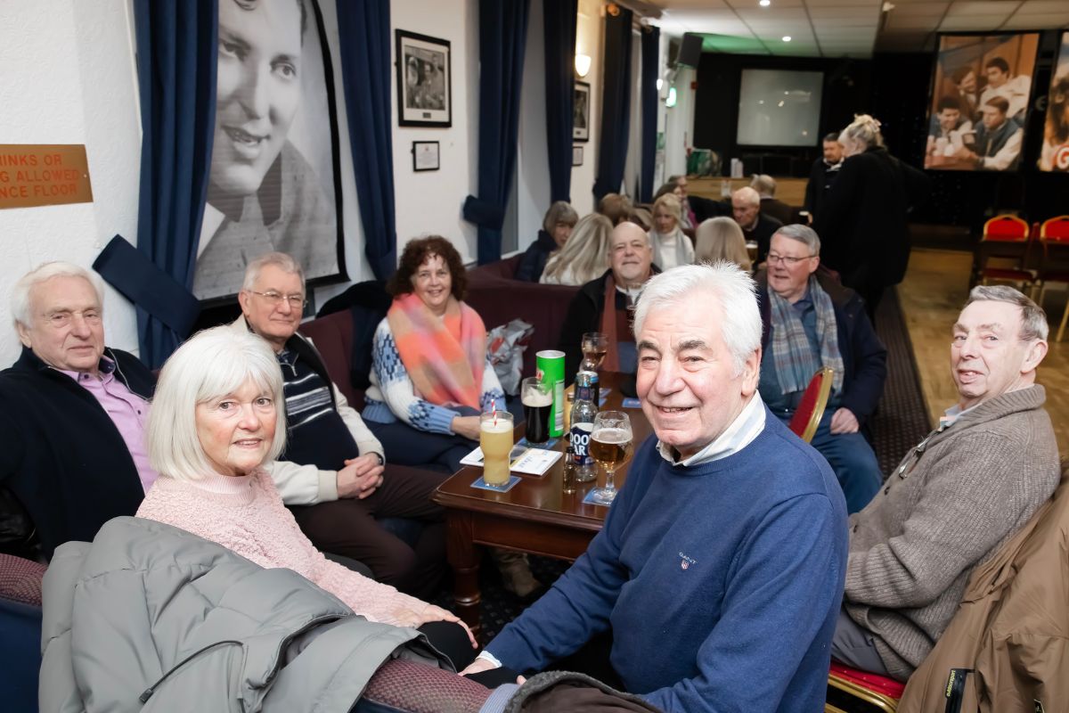A group of people sat around a table smiling