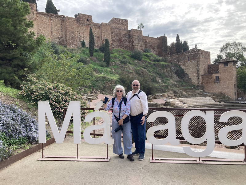Two people in a large 'Malaga' sign