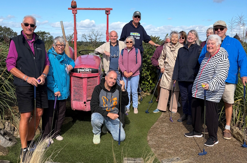 Around 13 members enjoying a round of adventure golf together