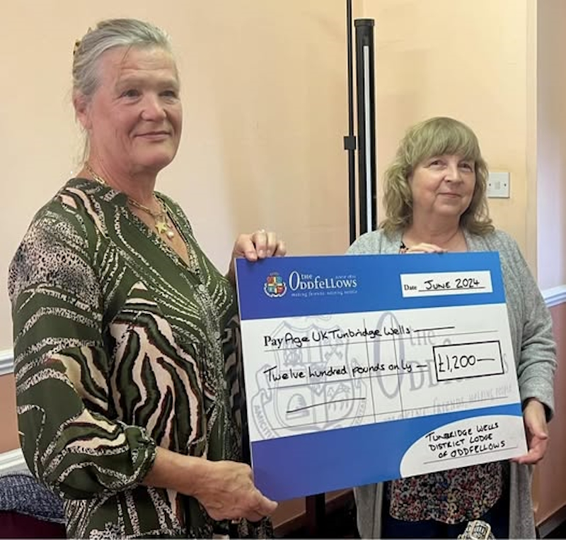 A member handing over the donation in the form of a big cheque