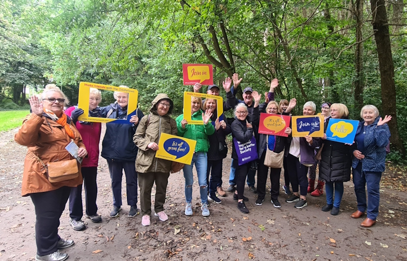 A group of members from Merseyside smiling and waving and about to head off on a group walk
